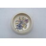 Moorcroft pin tray/ pin dish decorated with a blue and pink floral design set on a cream background.