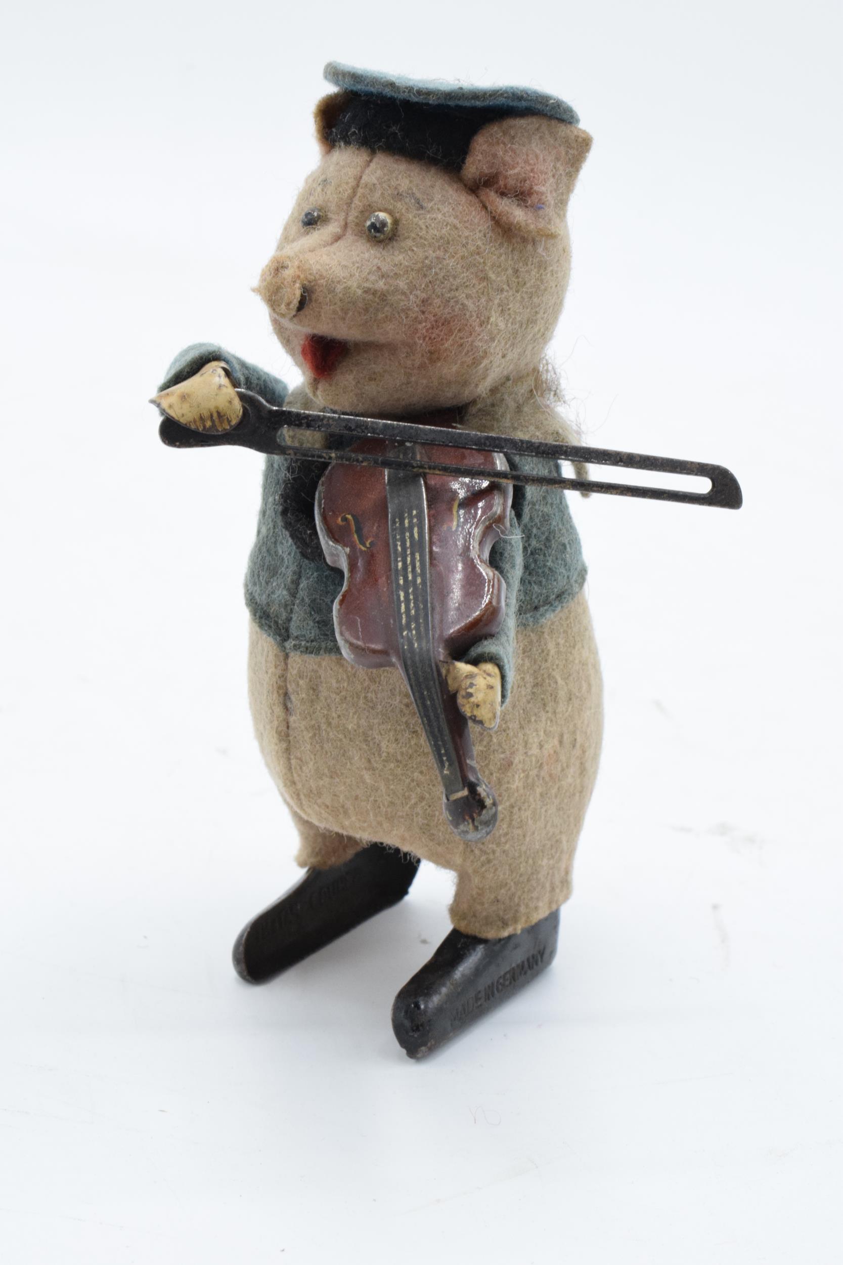 A Schuco circa 1930s clockwork toy figure in the form of a pig with a violin. Based on the Three