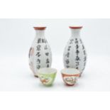 A pair of 20th century oriental sake bottles together with a pair of Chinese small soup / tea