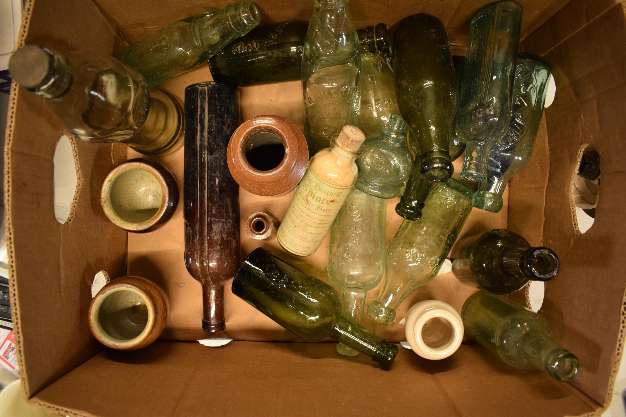 A mixed collection of vintage items to include stoneware jars and advertising glass bottles to