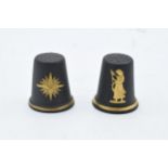 A pair of Wedgwood black Jasperware and gilded thimbles to include 1985 star and a lady in robes