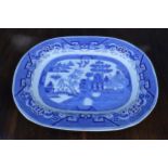 A large 19th century blue and white meat platter with transfer decoration of idealised landscape