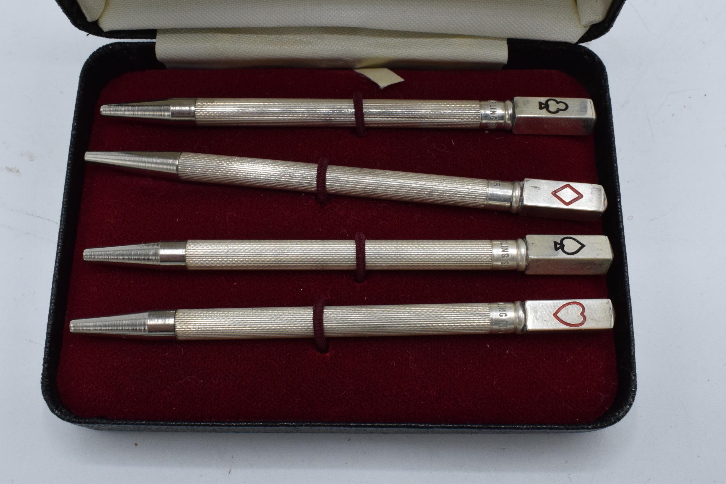 A sterling silver set of 4 bridge pencils with the tops of the pencils depicting the 4 suits. 9cm