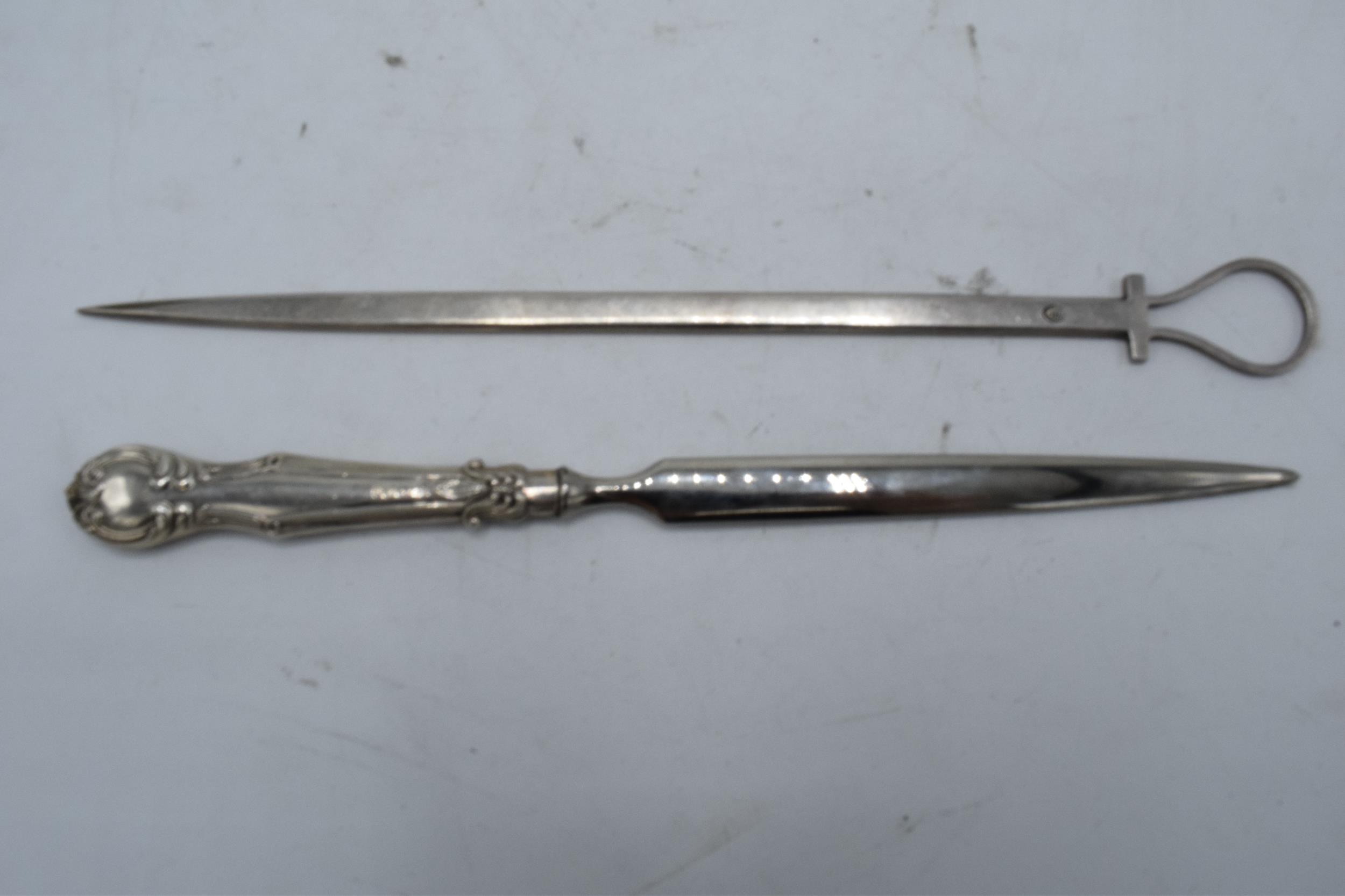 A silver handled letter opener together with a silver plated meat skewer (2).