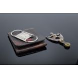 A silver cigar cutter in a leather case (Birmingham 1909) together with a steel example in the