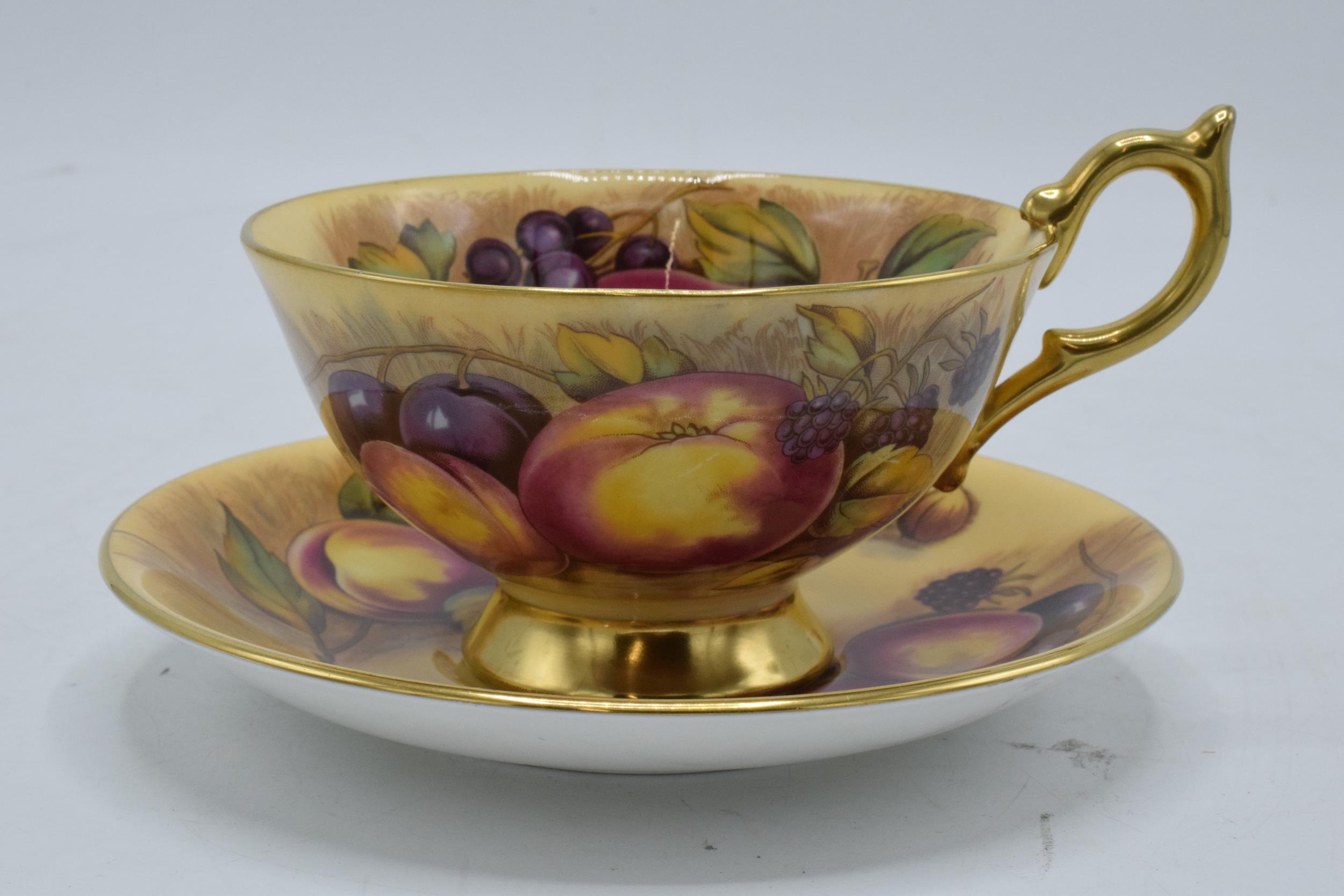 Aynsley cup and saucer in the Orchard Gold design (2). Both pieces are signed by N. Brunt. In good