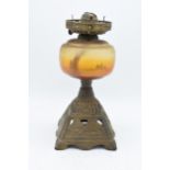 An early 20th century oil lamp with a cast iron base depicting sailing scenes. 32cm tall. In good