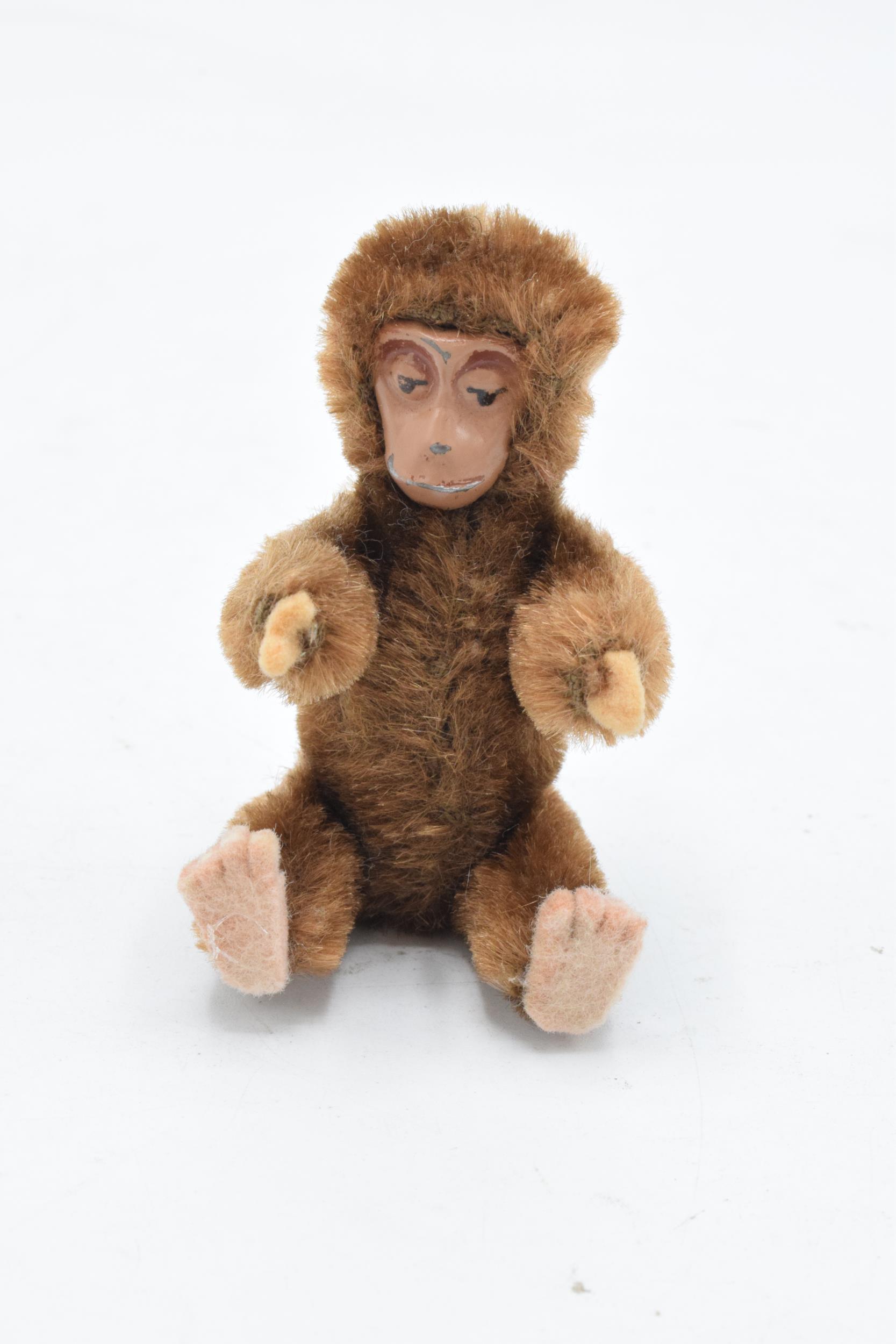 A 1930s/ 1940s miniature Schuco monkey, mohair body, painted tin-plate face, rotating head and