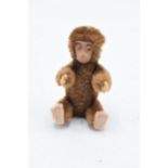 A 1930s/ 1940s miniature Schuco monkey, mohair body, painted tin-plate face, rotating head and