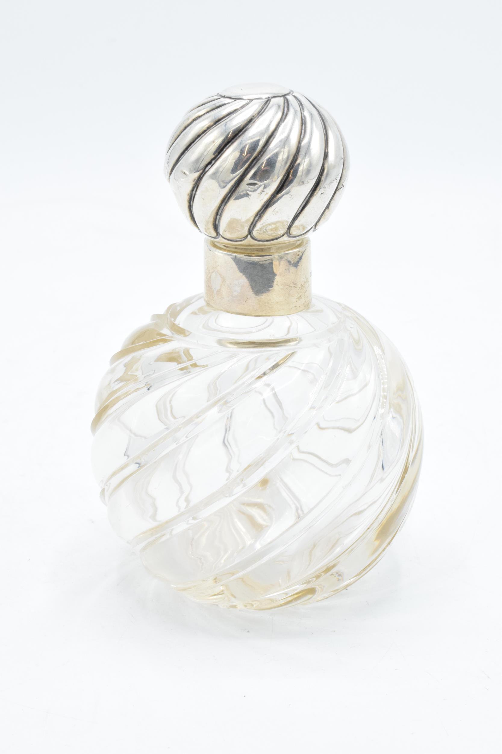 Silver topped scent bottle with swirling glass decoration 13cm tall. Hallmarked for London,