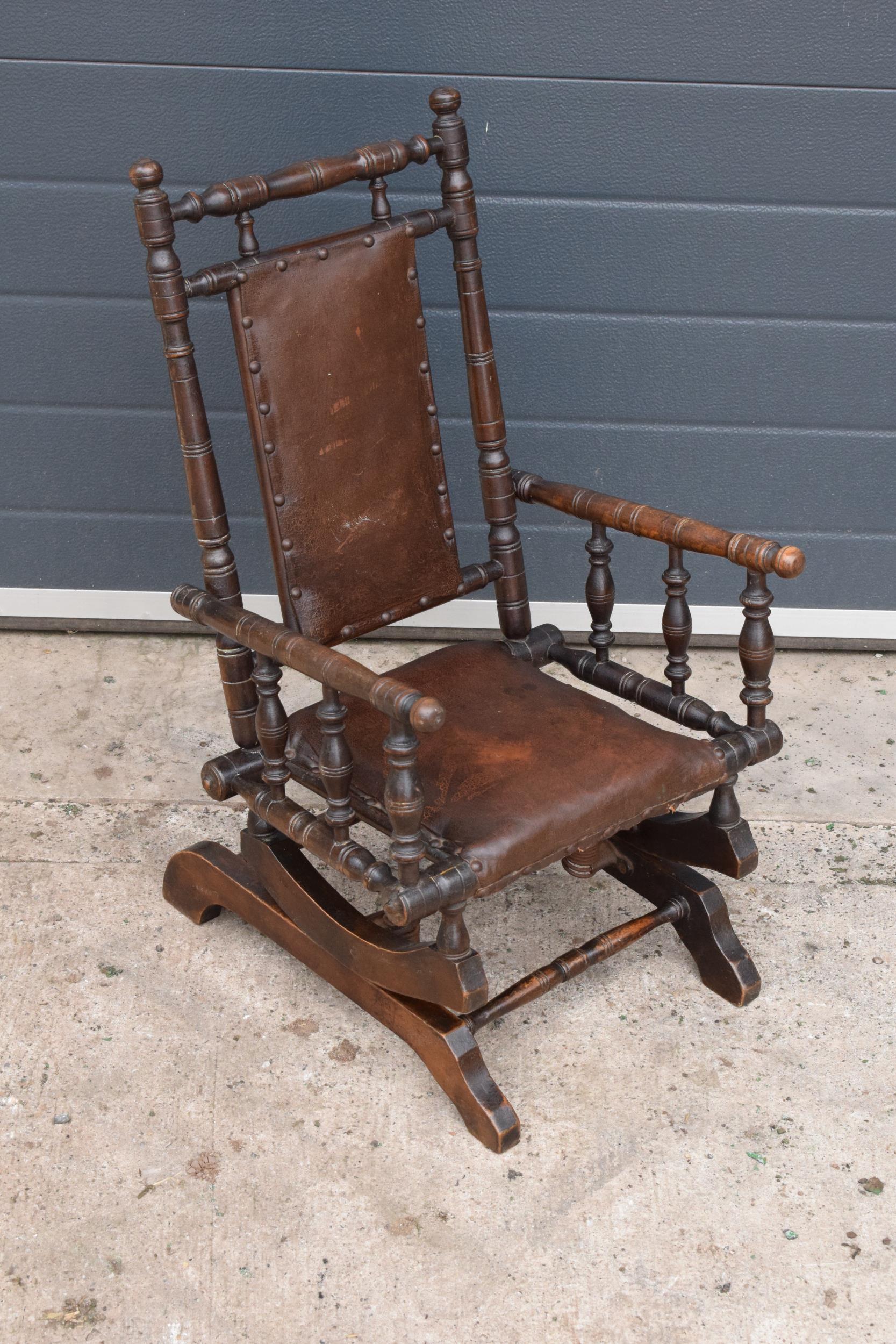 An early 20th century wooden childs American-style bobbin rocking armchair. 72cm tall. In good