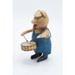 A Schuco circa 1930s clockwork toy figure in the form of a pig with a drum. Based on the Three