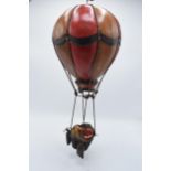 A painted hanging model of a hot air balloon group, the red and white balloon above a wicker