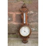 A late Victorian/ Edwardian arts and crafts style carved aneroid barometer. 105cm tall. There are