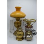 A collection of vintage oil lamps to include brass and pottery examples with associated chimneys and