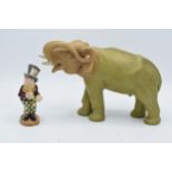 A Royal Dux (or similar) model of an elephant with trunk raised and numerals impressed in the