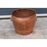 An early 20th century copper cauldron / log basket with brass handles and three claw feet. 24cm