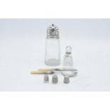 A collection of silver items to include a silver topped shaker, a perfume bottle with a silver neck,