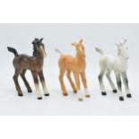 A collection of Beswick comical-type foal 728 in various colourways to include brown, grey and