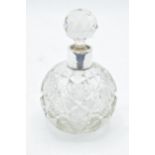 A glass scent bottle with a silver collar and associated stopper. Birmingham 1901. In good condition