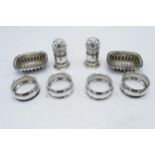 A collection of silver items to include a pair of table salts, 4 napkin rings and a pair of cruets