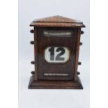 An early 20th century wooden perpetual calendar with separate scrolls for the day of the week,