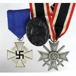 German Nazi War Merit Cross with Swords, Black Wounds Badge, and 25 Years Faithful Service Medal. (