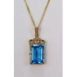 9ct yellow gold pendant set with an octagon Swiss blue topaz measuring 18mm x 13mm, accented by
