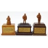 Three hand carved wooden figures, depicting interesting characters in history, each mounted on a