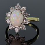 Tests as 18ct yellow gold cluster ring set with a central oval shaped opal cabochon measuring