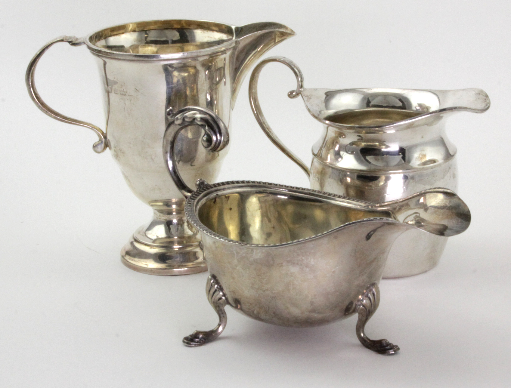 Three silver milk & cream jugs, hallmarked Birmingham 1933 & 1939 (one unreadable), tallest 10cm,