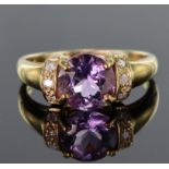 9ct yellow gold rinig set with a round 8mm 1.46ct amethyst highlighted on either side by a group