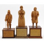 Three hand carved wooden figures, depicting interesting characters in history, each mounted on a