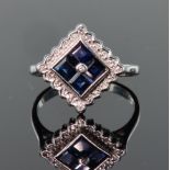 9ct white gold ring set with four princess cut sapphires in an offset square shape, surrounded by