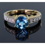 9ct yellow gold ring set with single 7mm round Swiss blue topaz with four 1.7mm round diamonds on