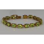 9ct yellow gold tennis bracelet set with sixteen oval 8mm x 6mm peridot, totalling 18.59ct with