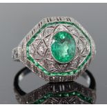 Platinum emerald and diamond Art Deco style bombe shaped ring comprising central oval emerald