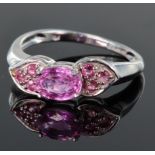 9ct white gold ring set with central oval 6mm x 5mm pink sapphire, bordered either side by a panel