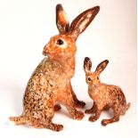 Set of Two Winstanley Hares. Size 6 and size 2. Hand made and painted with cathedral glass eyes.