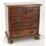 Small mahogany table / collectors cabinet, comprising of five drawers, raised on four ball feet,