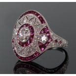 Platinum ruby and diamond ring comprising a central oval diamond weighing 0.49ct surrounded by a row