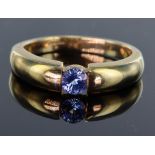 9ct yellow gold illusion tension set band ring set with single 4.8mm round Ceylon sapphire, weighing