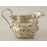 Victorian silver ornately decorated cream jug, raised on four feet, hallmarked 'C.SH, London