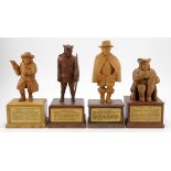 Four hand carved wooden figures, depicting interesting characters in history, each mounted on a hand
