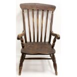 A small Victorian lathe back grandfather chair with solid saddle seat, on turned legs.