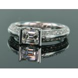 18ct white gold diamond ring consisting of central emerald cut bar set diamond weighing 0.79ct, with
