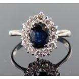 18ct white gold cluster ring consisting of an oval central sapphire measuring approx. 8mm x 6mm,