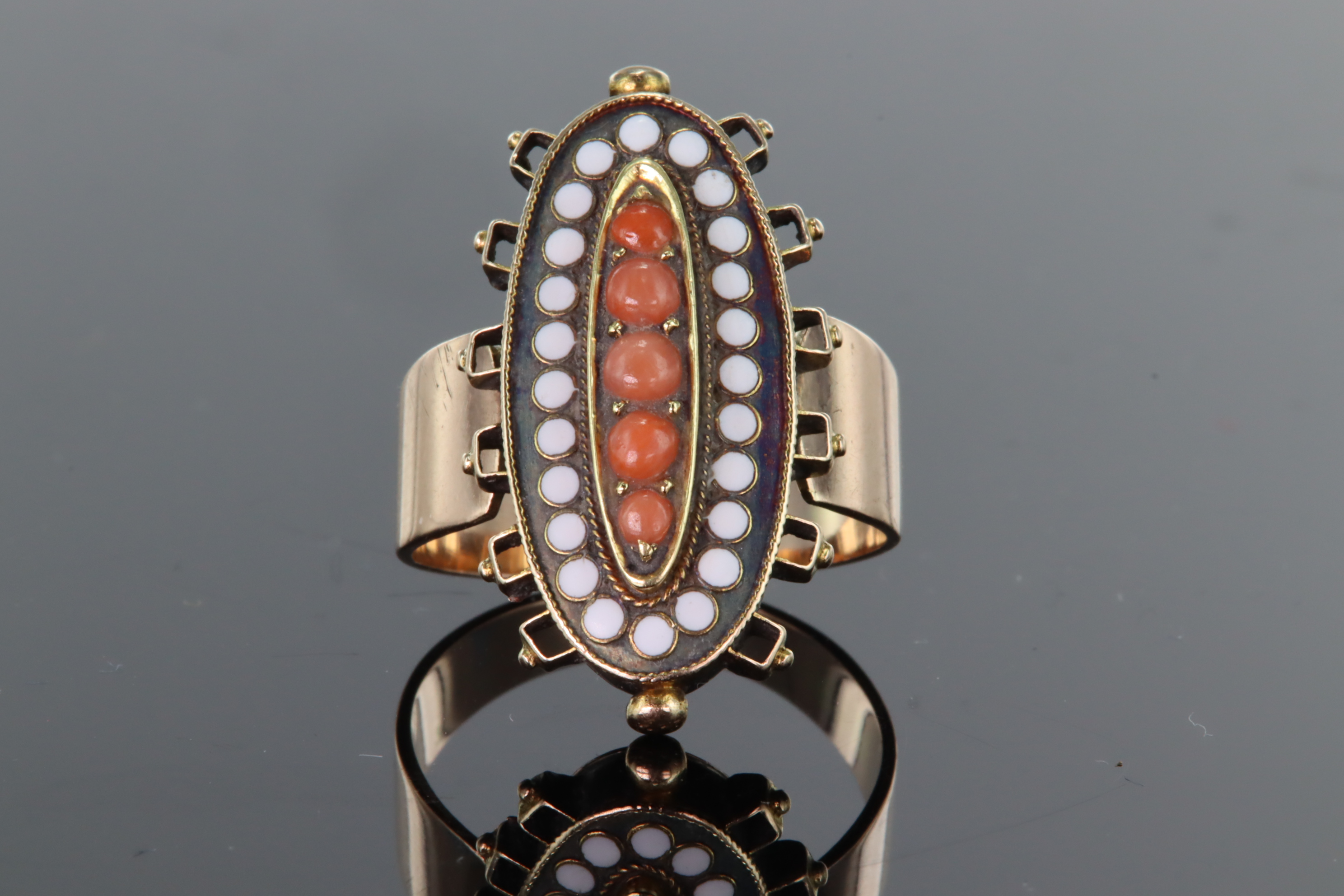 9ct yellow gold elongated oval dress ring set with raised central panel of five graduated coral