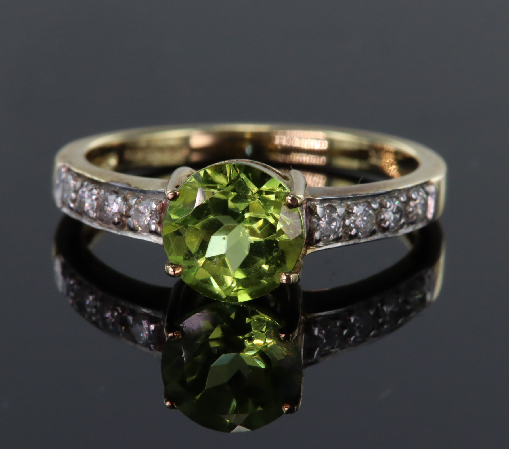 9ct yellow gold ring set with round 7mm peridot weighing 1.168ct in a four claw setting, bordered