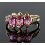 9ct yellow gold ring set with three oval 6mm x 4mm hot pink sapphires totalling 1.349ct and accented